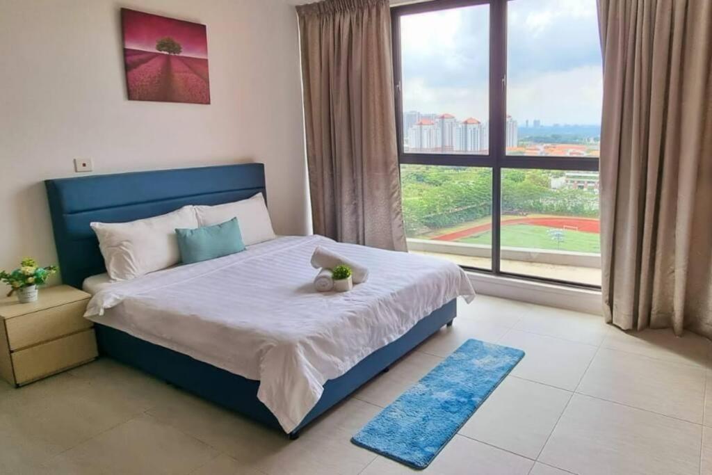 una camera con un grande letto e una grande finestra di Bell Suite a Sepang