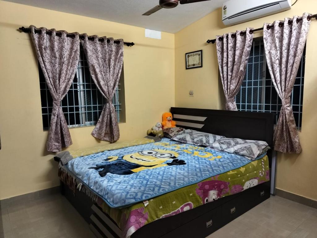 um quarto com uma cama com uma colcha de rato em PRATIKSHA - HOME FOR HOLIDAYS em Kundapur