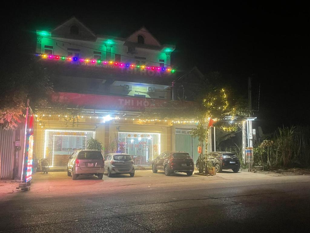 een gebouw met auto's geparkeerd op een parkeerplaats 's nachts bij Hotel Thi Hoa Bái Đính in Tiên Tân
