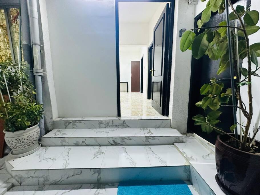 a door leading to a hallway with potted plants at Private Entrance 2 Bedroom Apartment fully furnished in Abu Dhabi