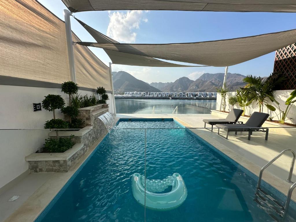 a swimming pool with a raft in the water at Al Dana Sea View Villa in Fujairah