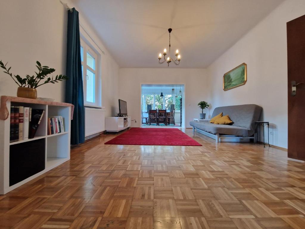sala de estar con sofá y alfombra roja en Geräumige und zentrale Ferienwohnung, en Stahnsdorf