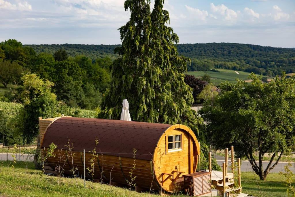 uma pequena casa num campo com uma árvore em Expérience insolite : tonneau merveilleux em Cormoyeux