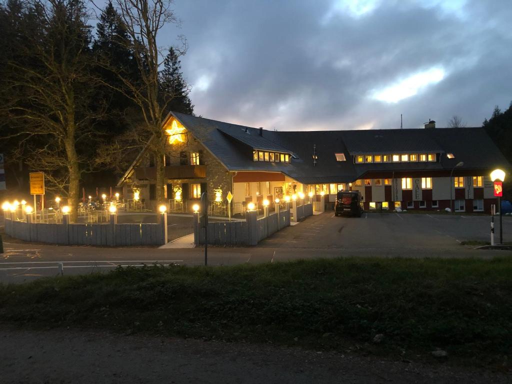 a building with lights in a parking lot at night at Waldhotel Auerhahn "Hochkopfhaus" in Todtnau