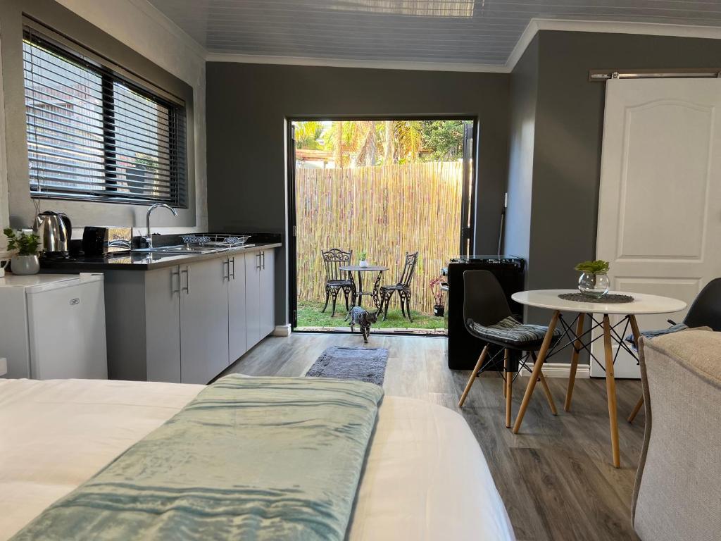 a kitchen and living room with a table and a table at The Charming Place in Cape Town