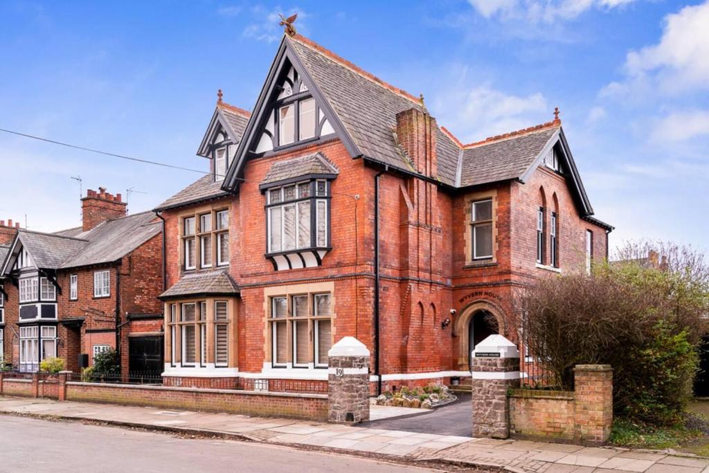 une maison en briques rouges avec un toit noir dans l'établissement Wonderful Stay 2 Bedrooms Flat, à Leicester