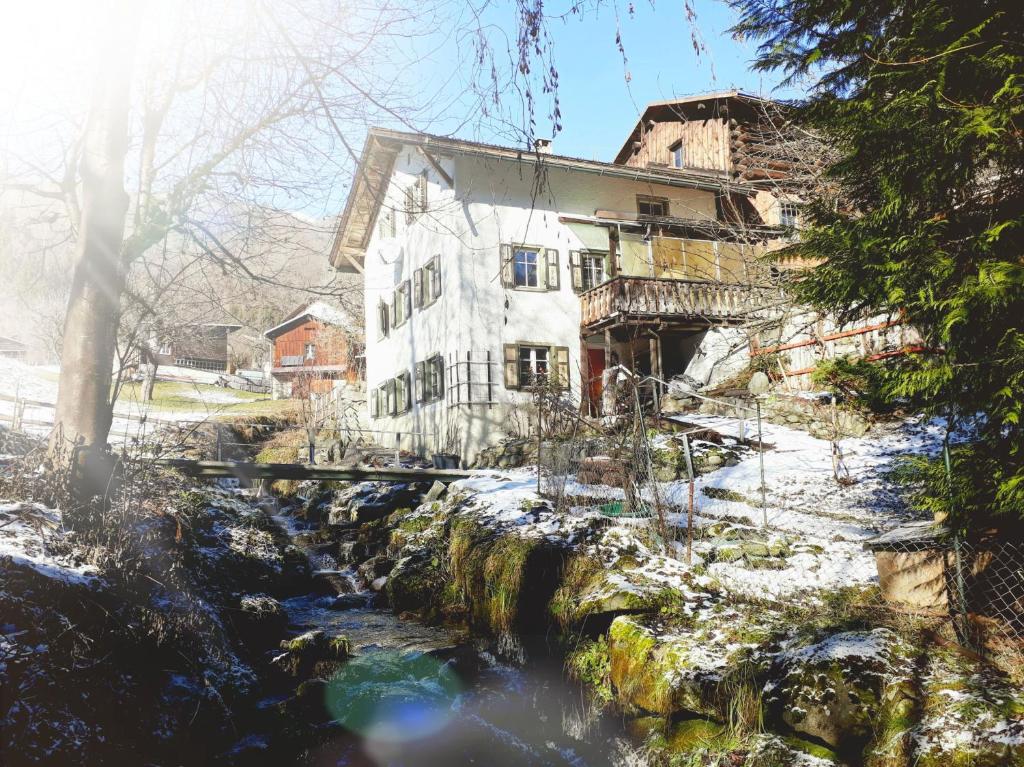 una casa vieja con un río delante de ella en Ferienhaus Signina, en Danis