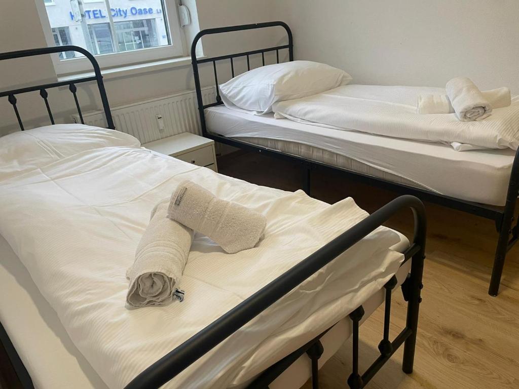 two beds with towels on them in a room at Timeless: 4 Zimmer Apartment Ludwigsburg in Ludwigsburg