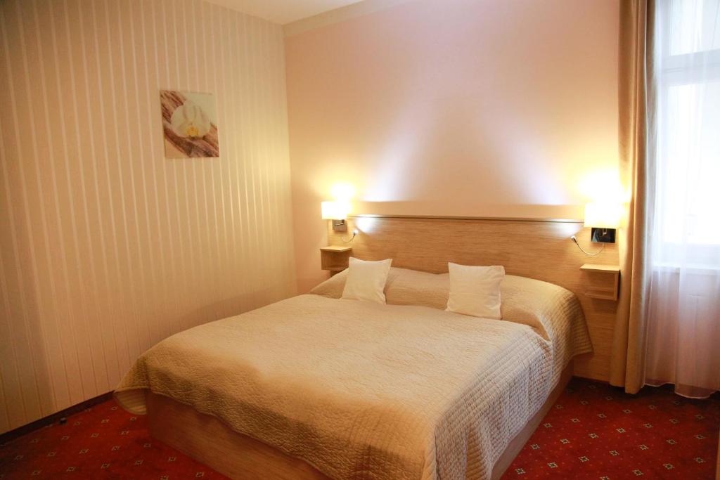 um quarto de hotel com uma cama com dois candeeiros em Pension Dvořák em Karlovy Vary