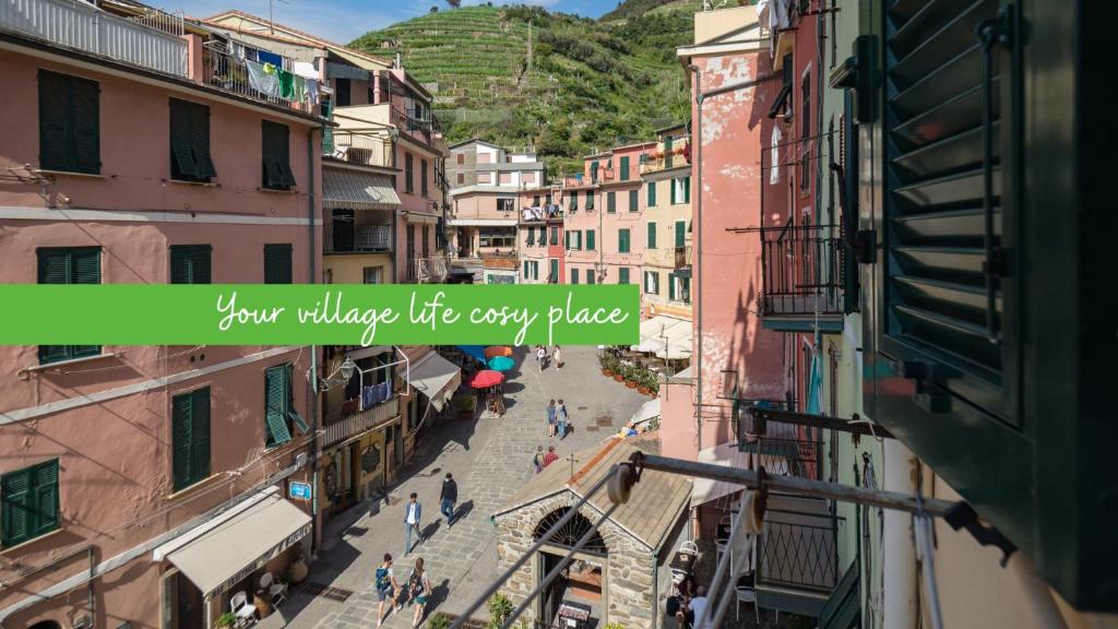 uma rua da cidade com edifícios e uma citação da sua vida na aldeia em todos os lugares em Nonna Rosetta Traditional Studio em Vernazza