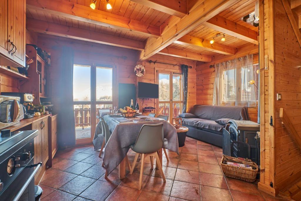 a kitchen and living room with a table and a couch at Le chalet Sylvaine in Le Dévoluy