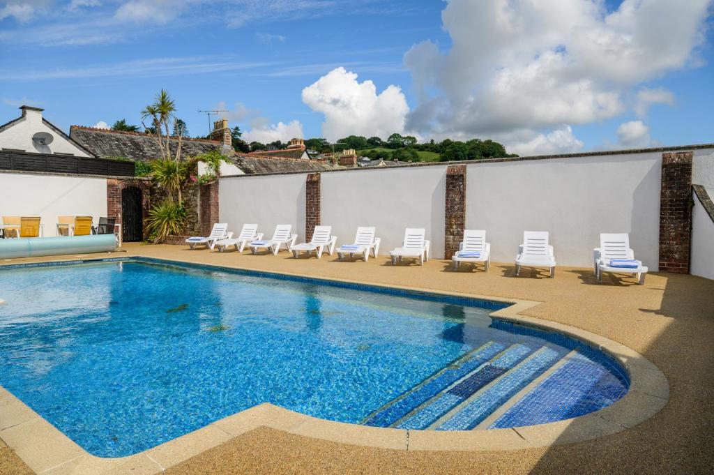 uma piscina com espreguiçadeiras e uma piscina em Best Western Fowey Valley em Lostwithiel