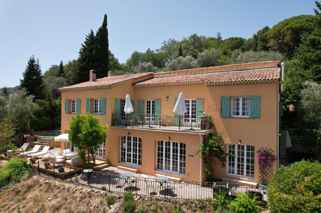 een uitzicht op een huis met stoelen en bomen bij Villa with panoramic views near Grasse- 2175 in Spéracèdes