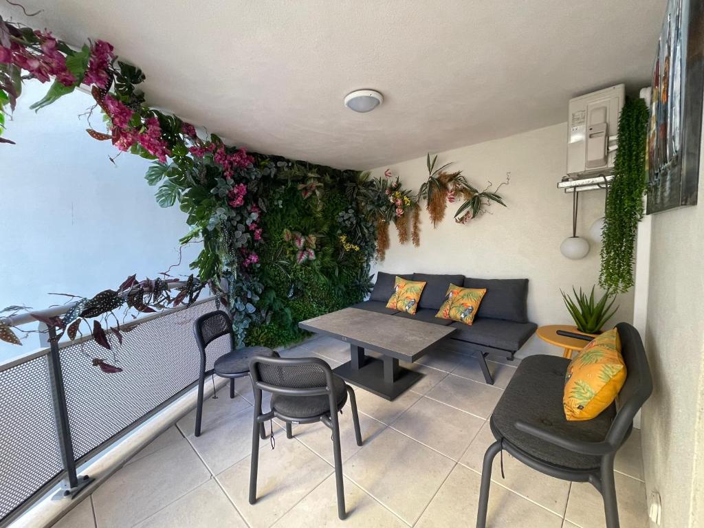 een balkon met een tafel, stoelen en bloemen bij Charmant studio au cœur du centre-ville in Calvi