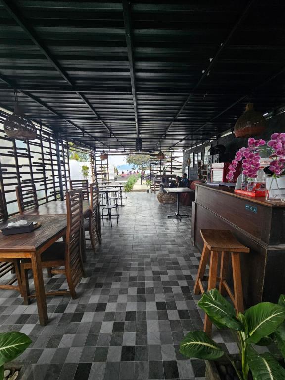 a restaurant with wooden tables and chairs and flowers at Glamour camping bedugul in Bedugul