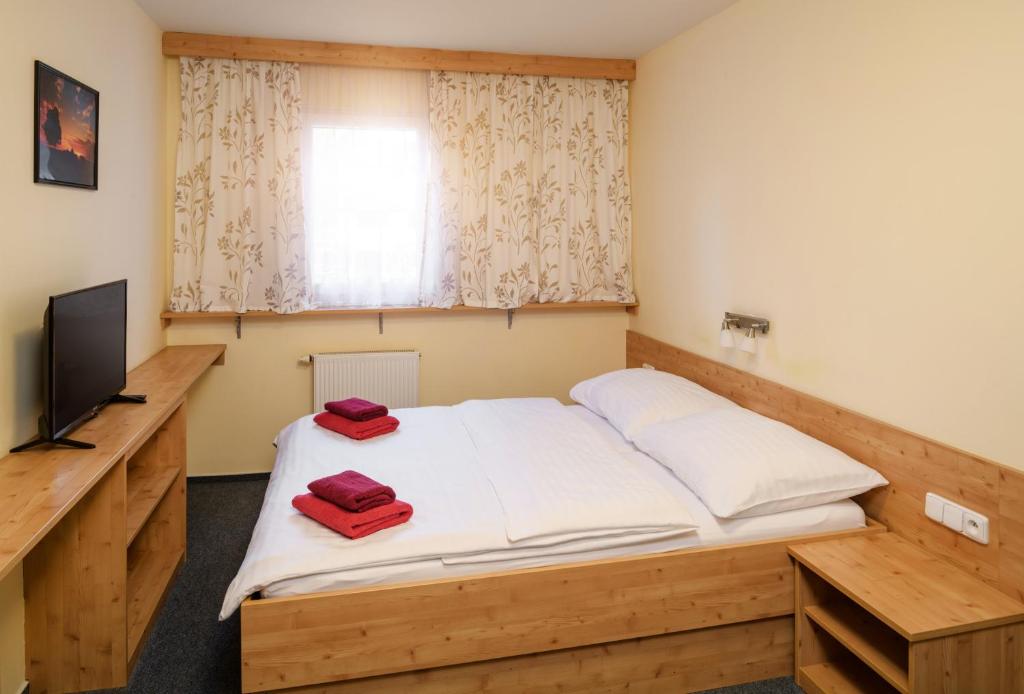 - une chambre avec un lit et 2 serviettes rouges dans l'établissement Horský Hotel Skiland, à Ostružná