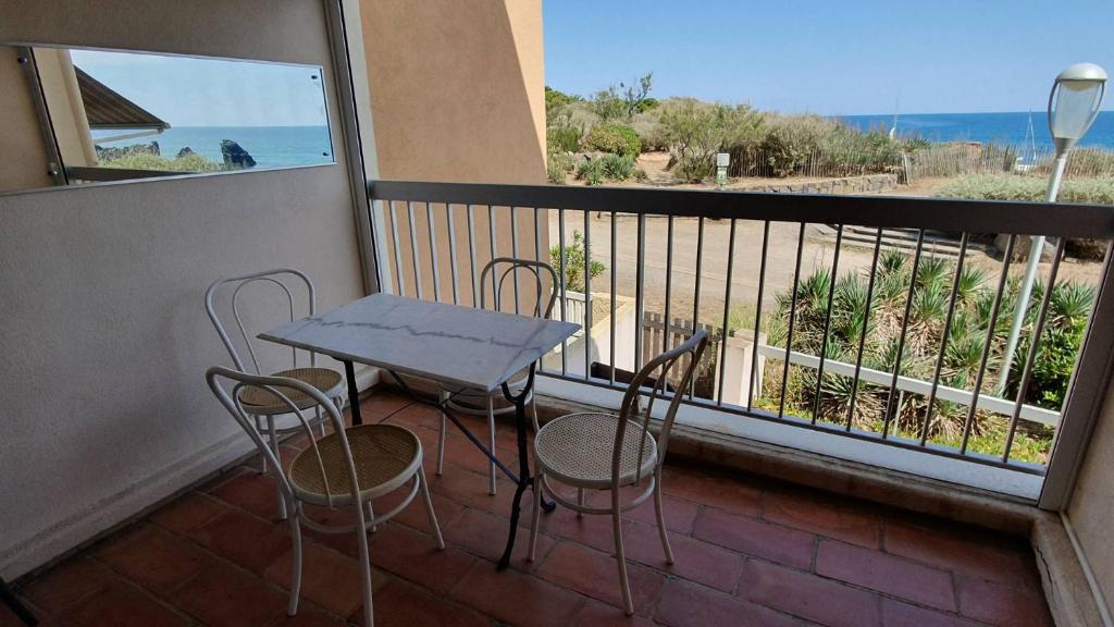 stół i krzesła na balkonie z widokiem na ocean w obiekcie 096 Roches Noiires A26 w Cap d'Agde