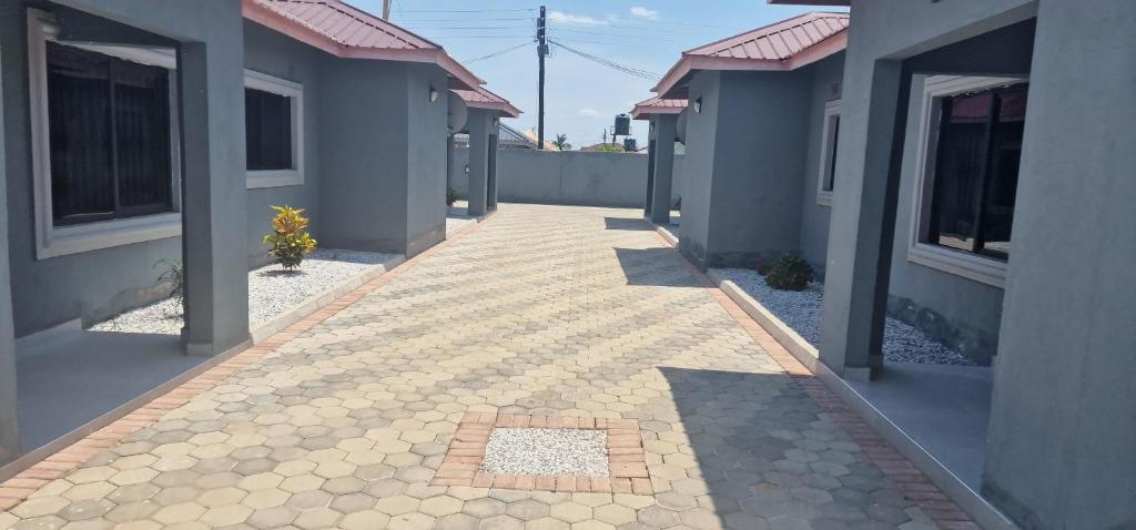 a walkway between two houses with a building at Salama Apartments in Lusaka