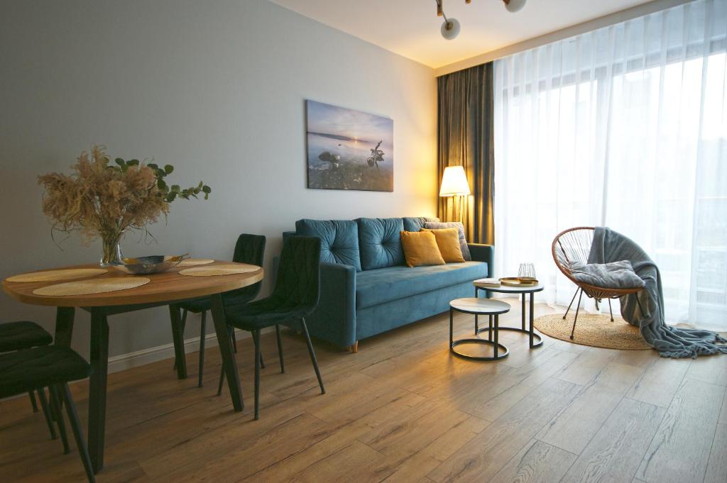 a living room with a blue couch and a table at IRS ROYAL APARTMENTS Apartamenty IRS Nadmorski Dwór 2 in Gdańsk