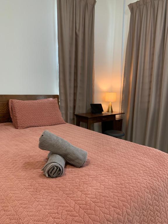 a stuffed animal is laying on a bed at A home with private pool, Kebun Kecil in Tangga Batu