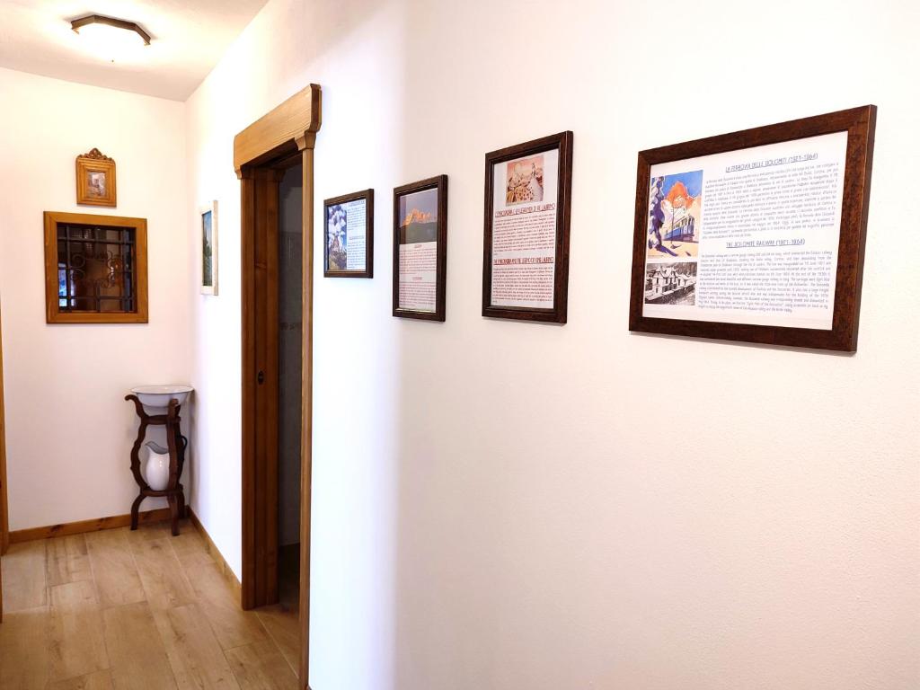 a hallway with framed pictures on a wall at Appartamento Pelmo in Borca di Cadore