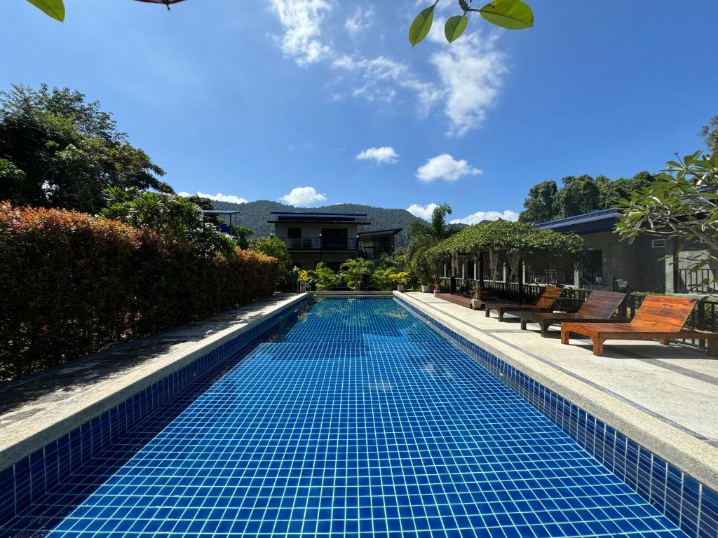 una piscina con azulejos azules en un patio trasero en BAAN CHAINARONG, en Ko Lanta