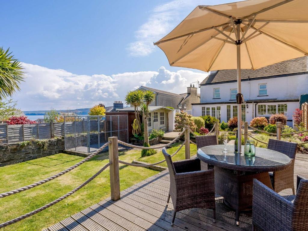 a wooden deck with a table and an umbrella at 4 Bed in New Quay 78589 in New Quay
