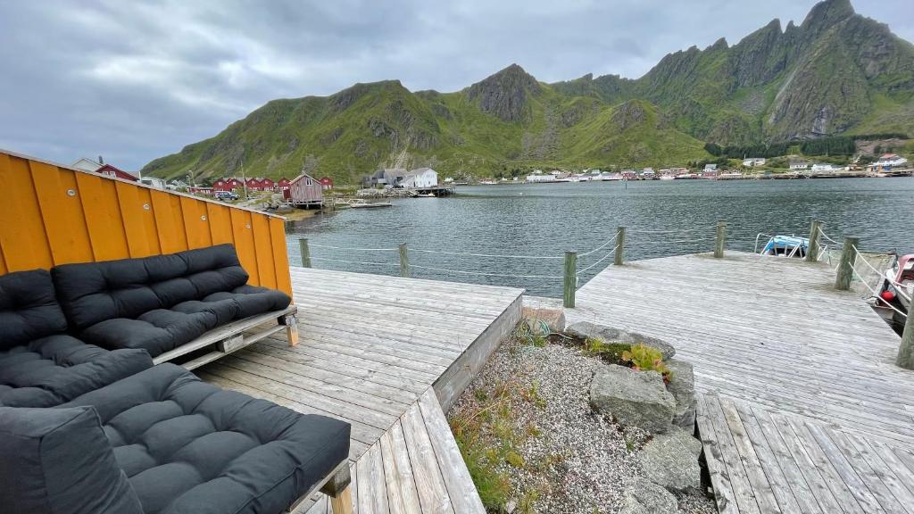 un muelle de madera con dos sofás junto al agua en Charming waterfront cabin in Ballstad, Lofoten en Ballstad