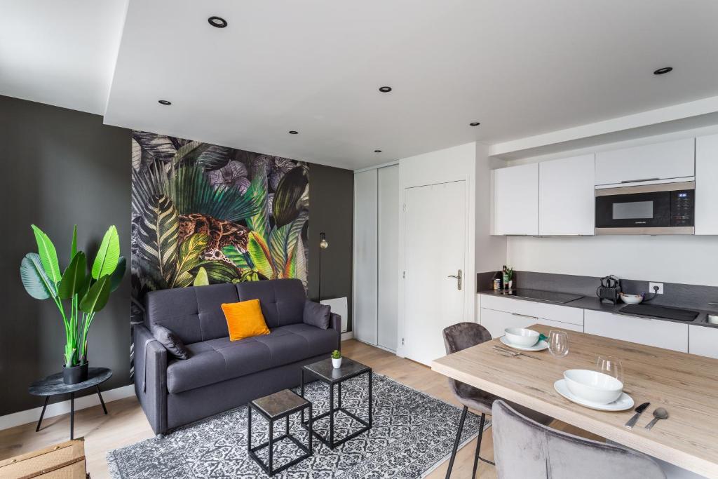 un salon avec un canapé et une table dans l'établissement Le Kipling - Studio de Standing à 5 min du centre Historique, à Rennes