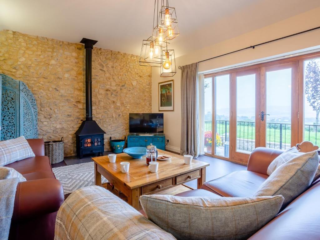 sala de estar con sofás, mesa y chimenea en 2 Bed in Axminster 79208, en Axminster