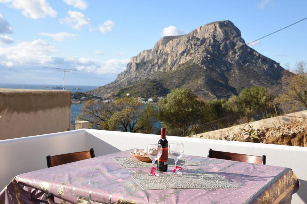 una mesa con una botella de vino en el balcón con una montaña en Vasilis House, en Myrties