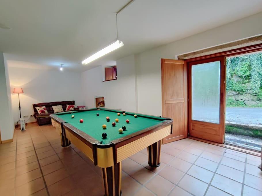 einen Billardtisch im Wohnzimmer mit Pool in der Unterkunft Casa da Telhada Pequena in Melgaço