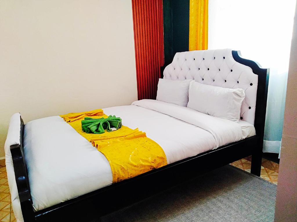 Una cama doble con una bolsa verde encima. en Cozy Haven Slumber en Nanyuki
