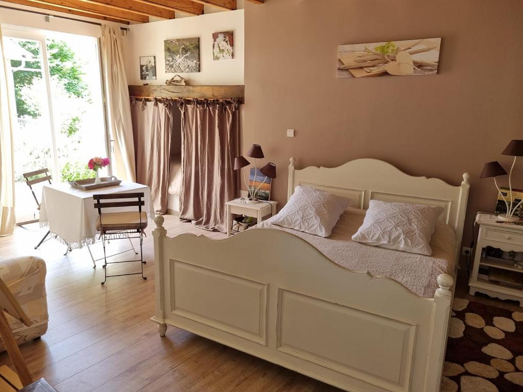 Schlafzimmer mit einem Bett, einem Tisch und einem Schreibtisch in der Unterkunft Chambre Nature Mondavezan in Mondavezan