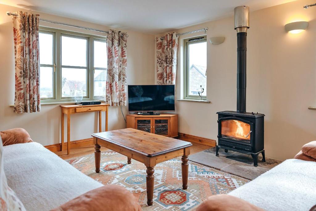 salon z kominkiem i piecem w obiekcie Finest Retreats - Norton Cottage w mieście Onibury