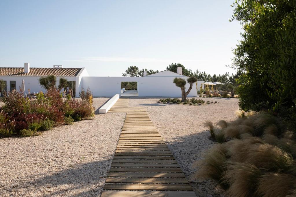 um caminho que leva a uma casa com um edifício em Amaria em Aljezur