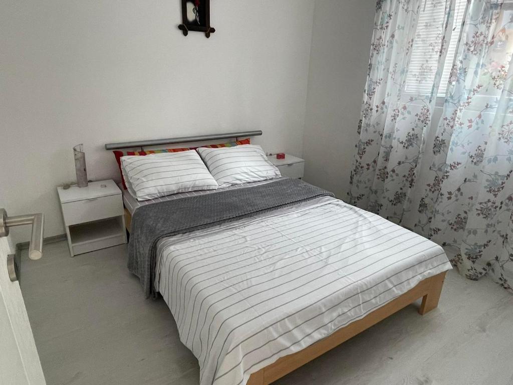 um quarto com uma cama grande e lençóis brancos em Apartman DB em Višegrad