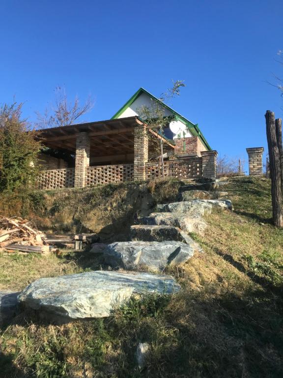 a house on a hill with rocks in front of it at Kőlépcsős Vendégház in Nyúl