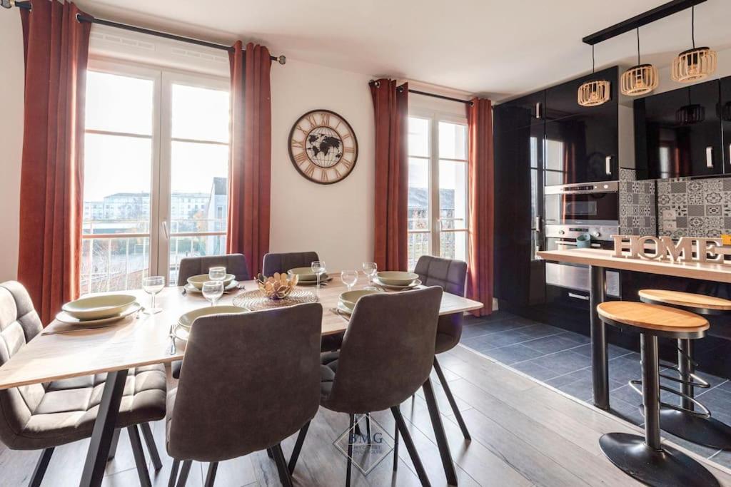 une salle à manger avec une table, des chaises et une horloge dans l'établissement Harmonie appartement Disneyland Paris, à Chessy