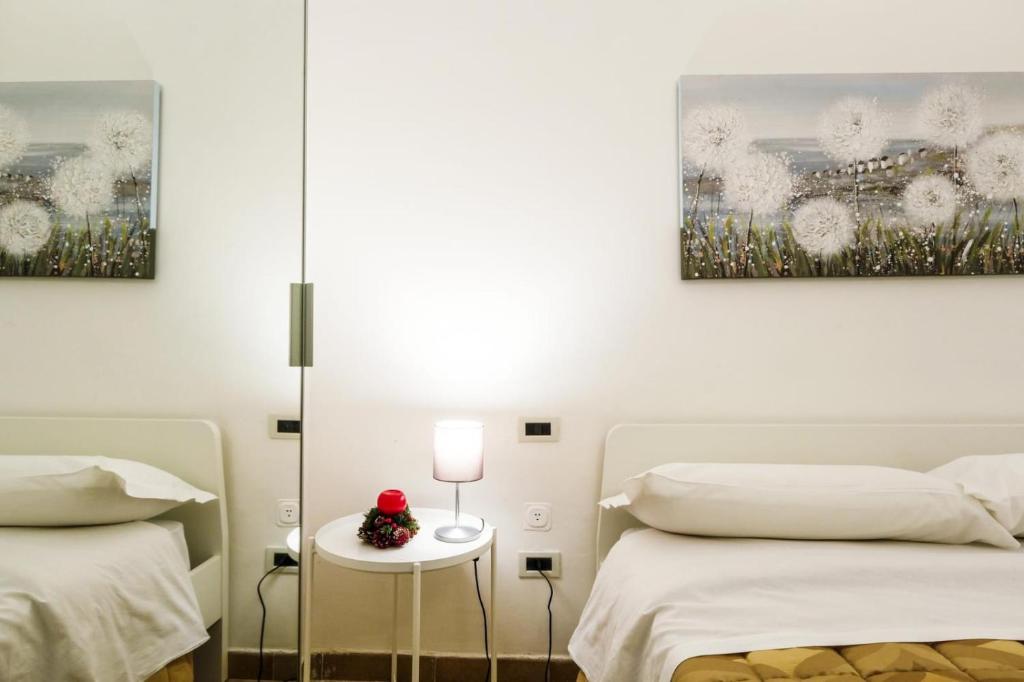 a bedroom with two beds and two paintings on the wall at Casa Vacanza La Fornace Matera centro in Matera