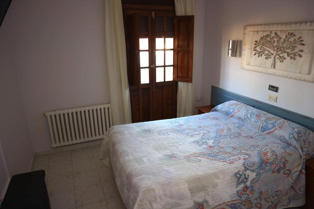 ラ・イスラにあるAlojamiento Monte y Marのベッドルーム1室(ベッド1台付)、窓、ドアが備わります。