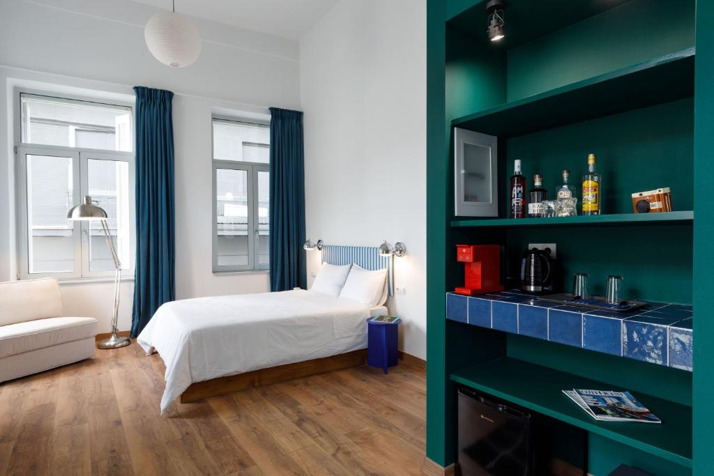 1 dormitorio con cama y pared verde en The Baroness, en Kalamata