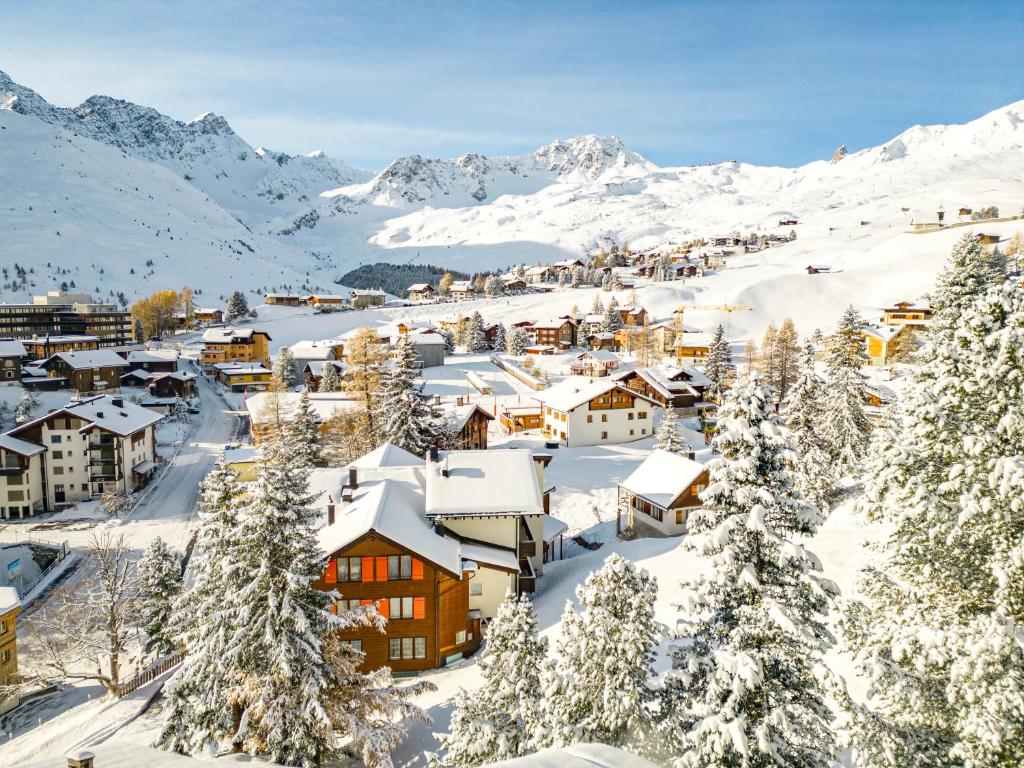 a town covered in snow with mountains in the background at Utoring 412 by Arosa Holiday in Arosa