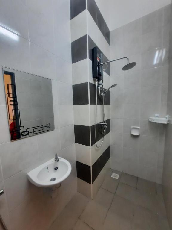 een zwart-witte badkamer met een wastafel en een douche bij D'homestay Parit Buntar in Parit Buntar