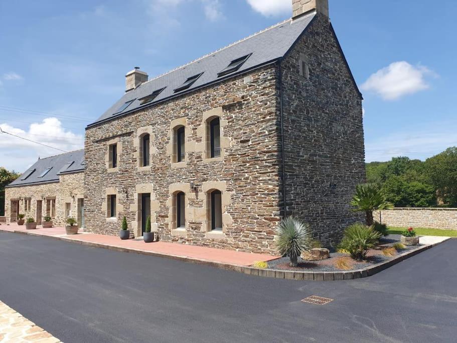 a large stone building with a black roof at Gîte Manoir de Kerlez Plain-pied in Briec