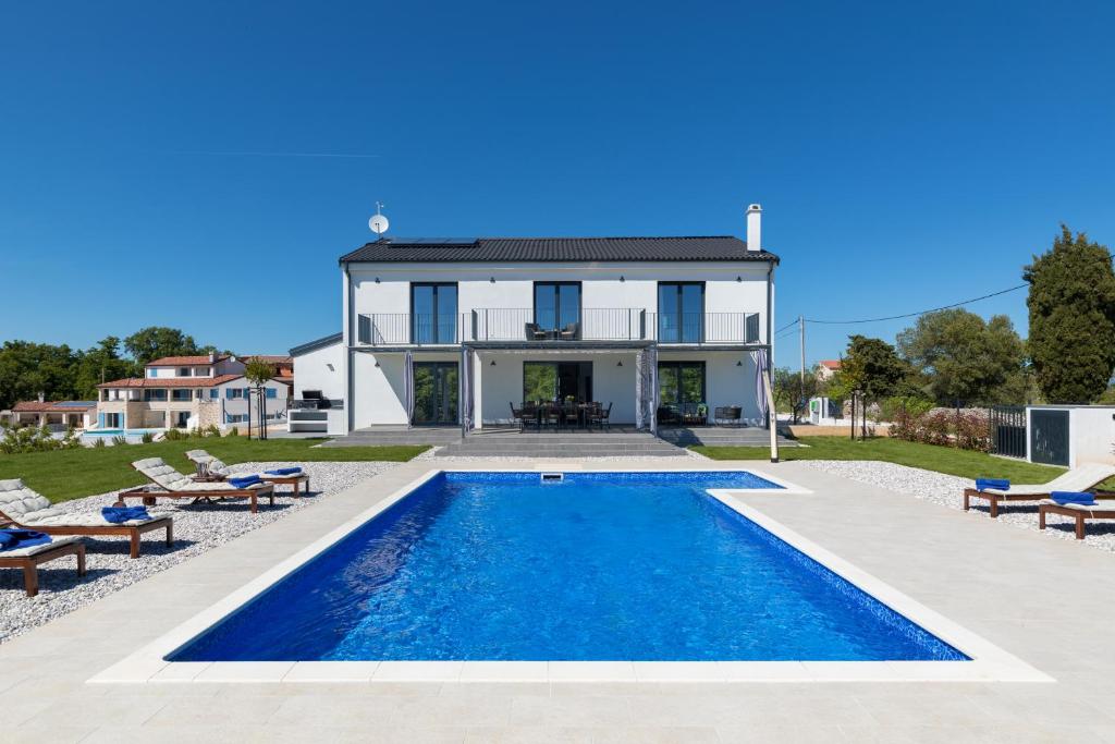 a villa with a swimming pool in front of a house at Dolce Bacio in Kavran