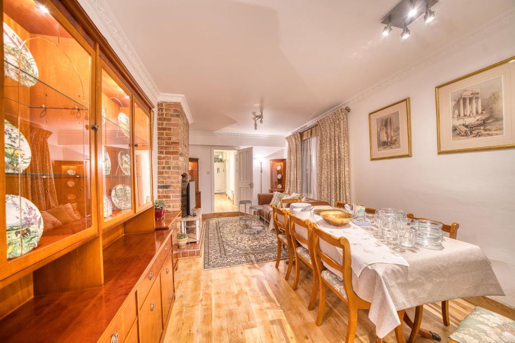 Luxury Terraced Victorian House في لندن: غرفة طعام مع طاولة وكراسي طويلة