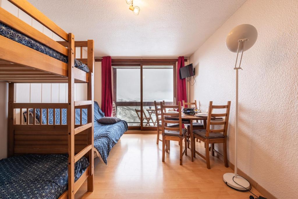 Cette chambre dispose d'une table à manger et de lits superposés. dans l'établissement L'Etoile Polaire - Appt vue montagne, à Villarembert