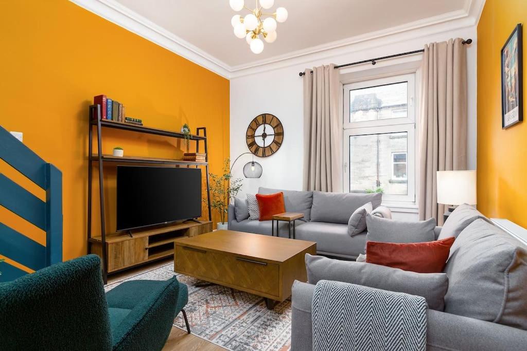 a living room with a couch and a tv at The Stylish 3-Bedroom Maisonette Retreat in Stirling