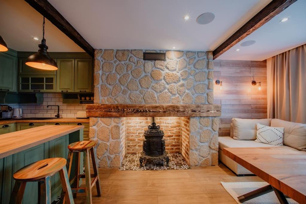 ein Wohnzimmer mit einem Steinkamin und einem Sofa in der Unterkunft The Owl's Nest 2 in Welingrad